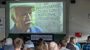 Zeigt eine Klasse bei einem Vortrag eines Zeitzeugen Zeigt eine Klasse bei einem Vortrag eines Zeitzeugen
