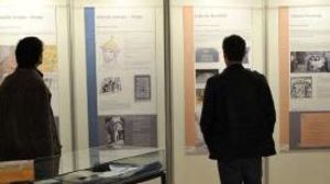 Zeigt Bild der Ausstellung mit Ausstellungstafeln und Besuchern